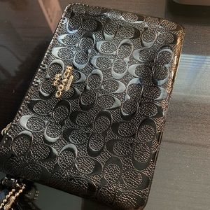 Coach, shiny, black wristlet wallet.